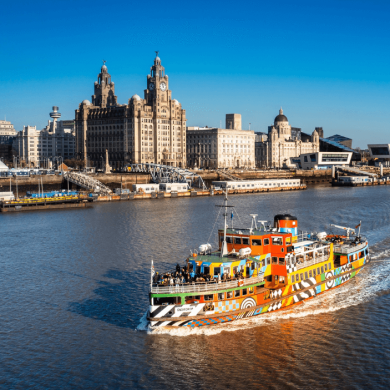 the mersey ferry on the river mersey with the three graces in the background.