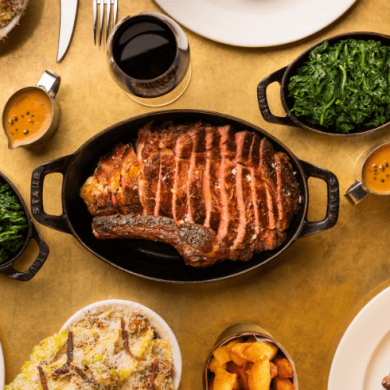 A bird's eye view of food on a table including steak, spinach and chips.