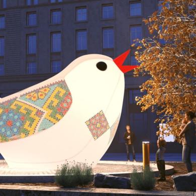 A large, illuminated bird sculpture on a water feature