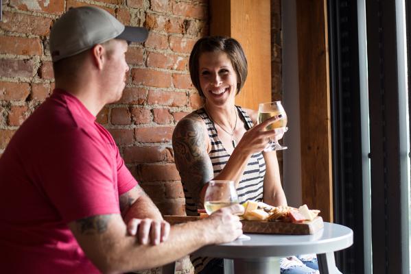 Couple eating and drinking at Aftermath Cidery