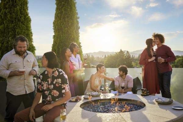 Friends drinking cocktails on Sky & Vine Rooftop at Archer