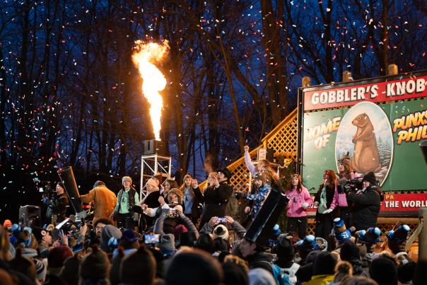 Huge crowd looking up at a stage that reads Gobblers Knob with people cheering and a blast of fire is coming out of a section of the stage