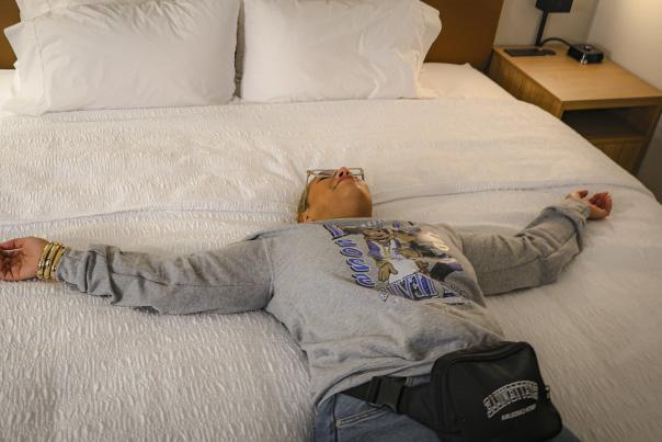 Traveler relaxing on a hotel bed in Fayetteville, North Carolina after visiting friends and family.