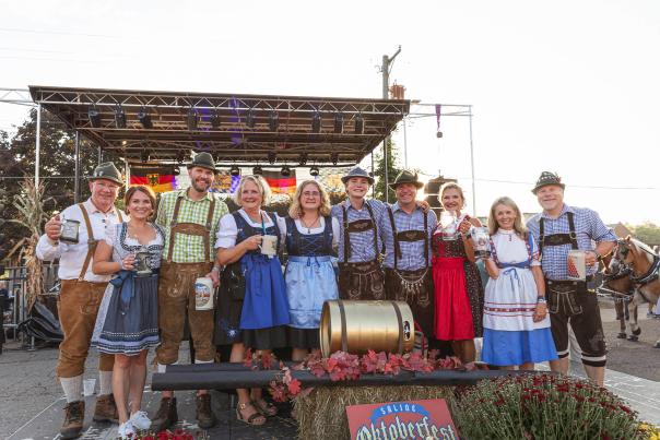 Row of people in German garb smiling for the camera at Saline Oktoberfest