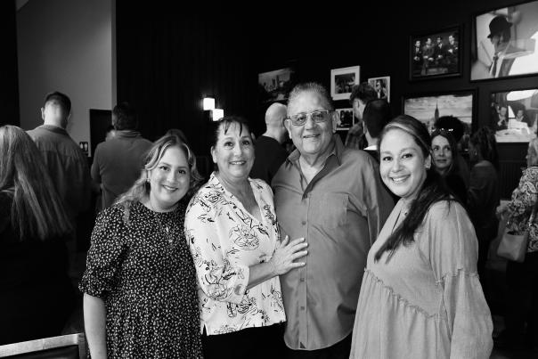 Fiori Owner, Orlando, smiling with wife and two daughters in restaurant.