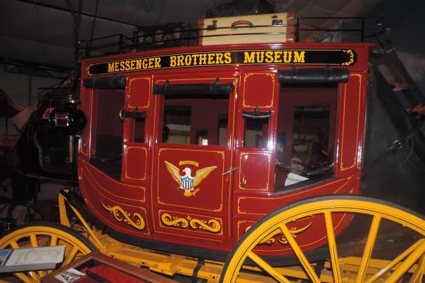 A red stagecoach with yellow wheels sits in the Messager Brothers Museum.