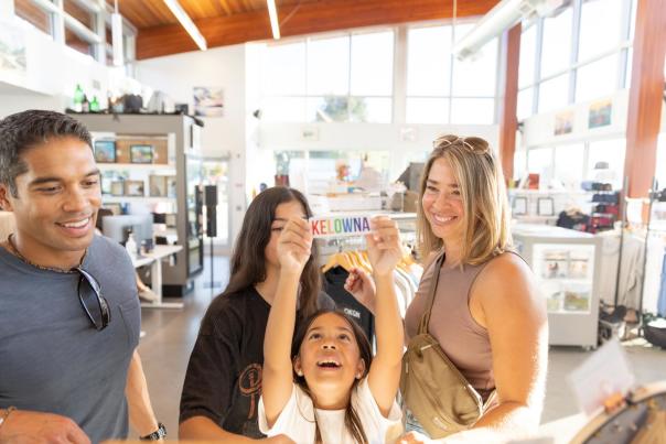 Family looking at stickers in the Kelowna Visitor Centre