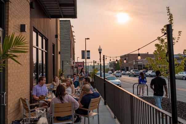 People sitting outside during sunset at a restaurant in the Blackstone District.