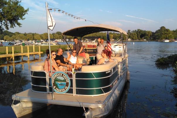 Pontoon with group of people waving from the back