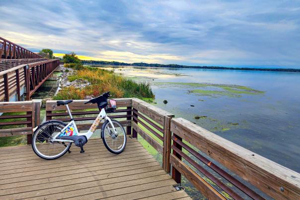 A BCycle electric bike rests on a foot bridge overseeing the lake