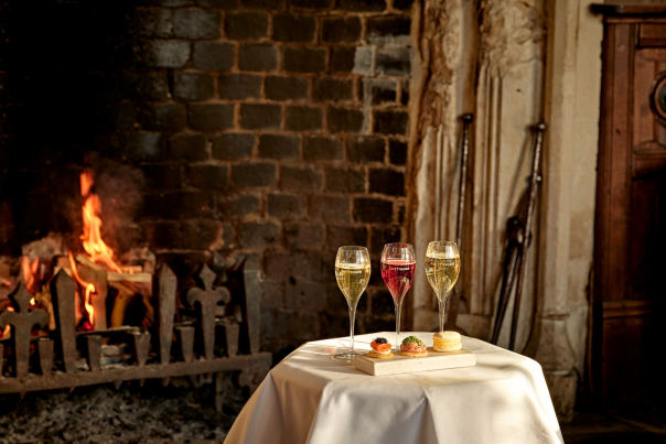 A table with drinks and canapes in front of a fire at Ellenborough Park