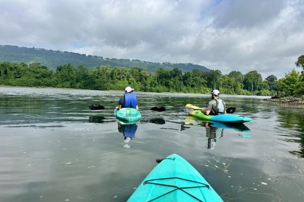 view from kayak of two other kayakers paddling the Tennessee River on their way to Williams Island