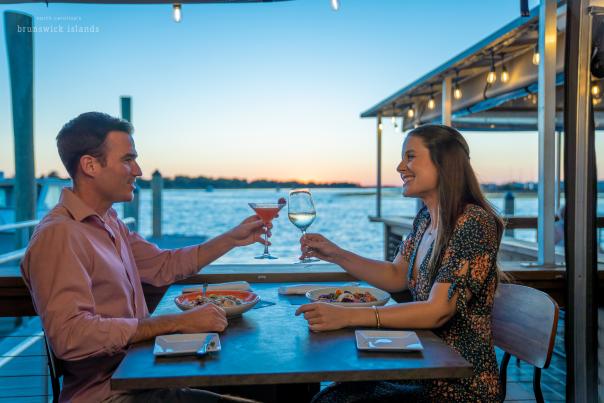 a couple toasting over a meal