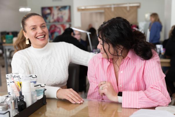 Two girls laughing at a nail salon