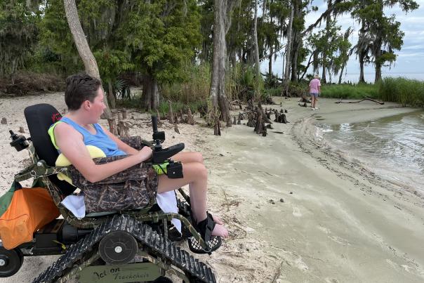 The author's daughter is seated in Fontainebleau State Park's all-track wheelchair on the beach inside the park.