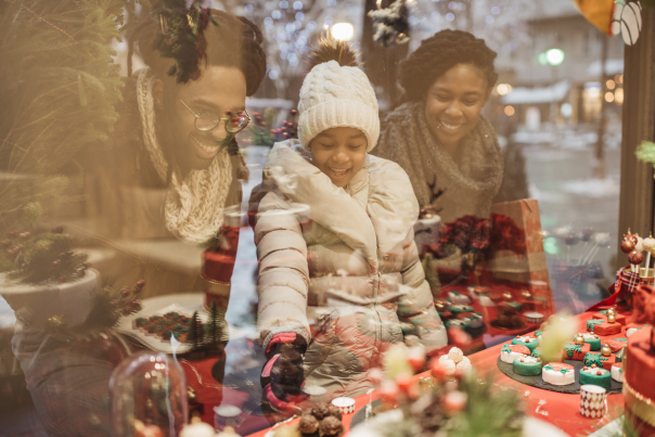 A family smiling as they window shop Christmas goodies in Vancouver, WA.