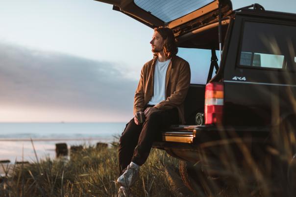 Person sat on tailgate on car next to the beach in East Yorkshire