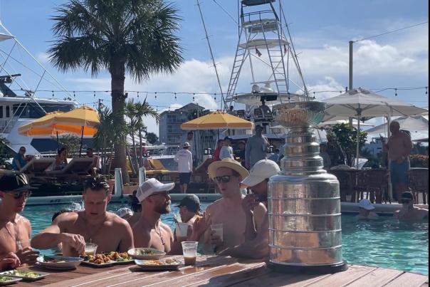 Florida Panthers teammates enjoying snacks in the pool at Sands Harbor Resort & Marina. They have the Stanley Cup trophy sitting on the in-pool table.