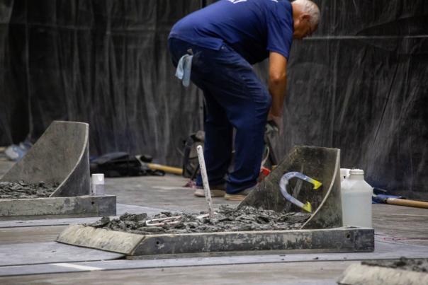 A horseshoe being tossed into a horseshoe pit.