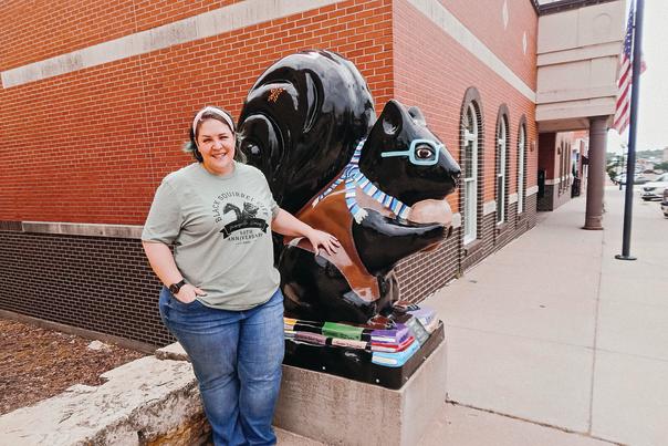 Woman stands by human-sized squirrel statue