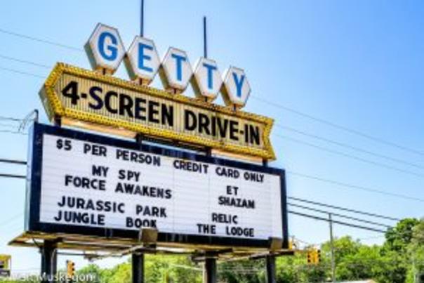 marquee for getty 4 screen drive-in. Getty is in blue letters set in white hexagons. 4 screen drive in is in gold arrow. below is a white marquee with movie titles