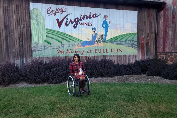 Maggie in front of an Enjoy Virginia Wines mural at the Winery at Bull Run in Fairfax County, Virginia