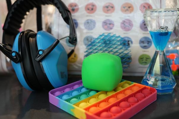 Clayton Community Center Sensory Kit items on display including headphones and a fidget toy.