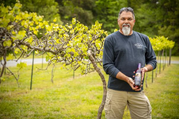 Man holding wine bottle in vineyard
