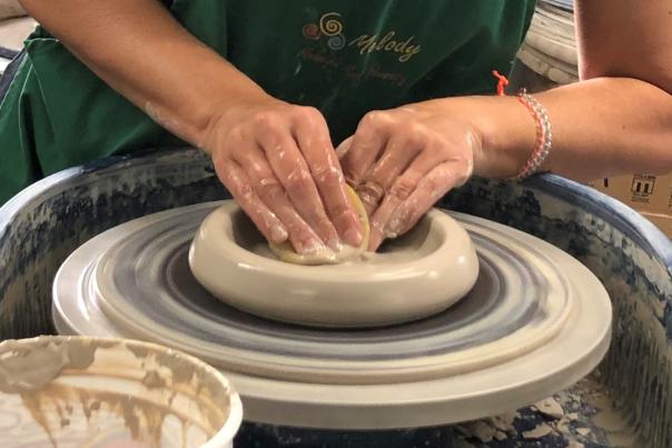 hands working with clay on a potter's wheel