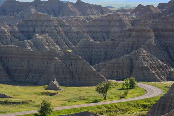 road driving into the towering landscape of badlands national park in south dakota