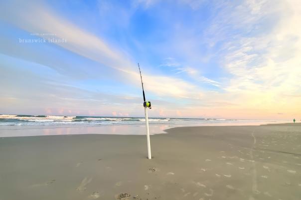 fishing pole on a beach embedded in sand