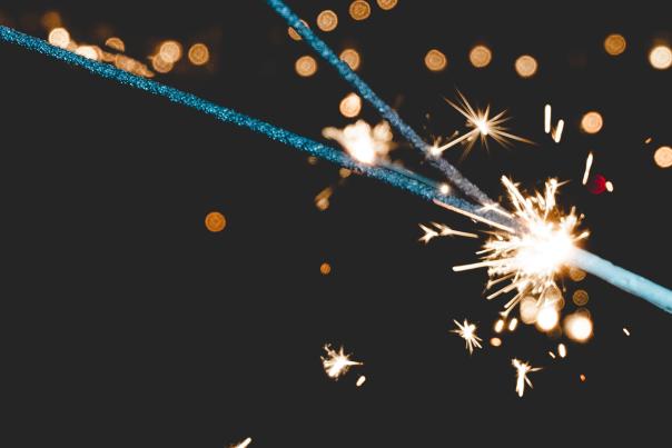 A sparkler being lit against a dark background
