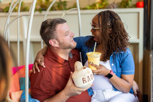 Couple sitting closely in the same chair while happily drinking beverages at Rasa Restaurant in Merrifield.