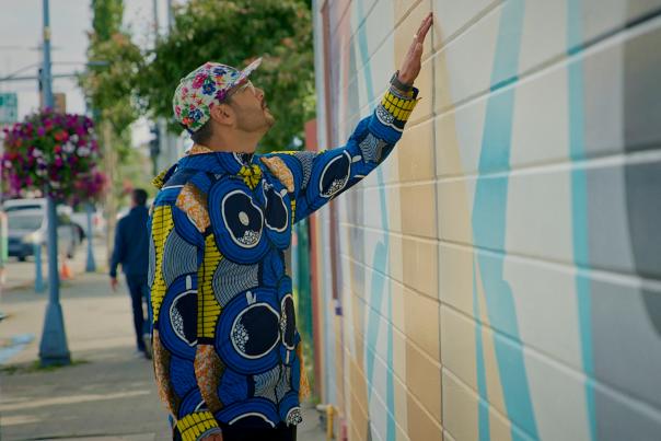 Artist Drew Michael looks at his mural on the side of the Kobuk.
