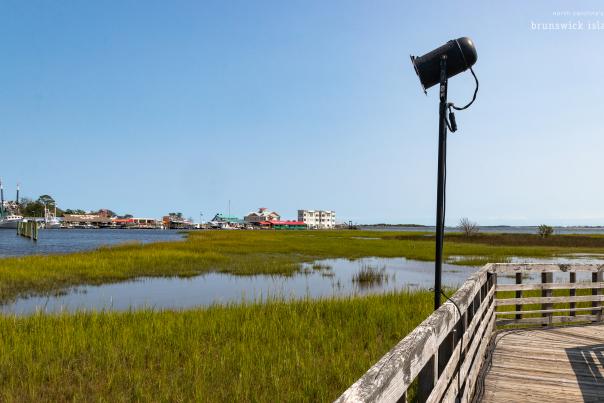 a movie spotlight along a wooden walkway through the marsh in Southport.  NC