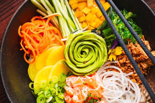 Two brightly coloured bowls of food with chopsticks