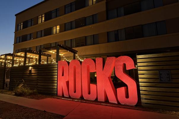 Origin Hotel Red Rocks sign that says ROCKS in red lit up at night with the hotel in the background