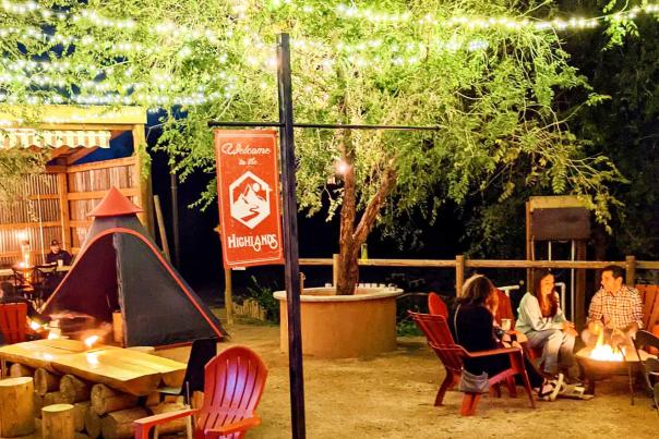 View of People around a firepit at Highlands Distillery