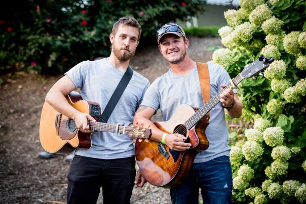 Two guys posing with their guitars outside at 868 Estate Vineyards