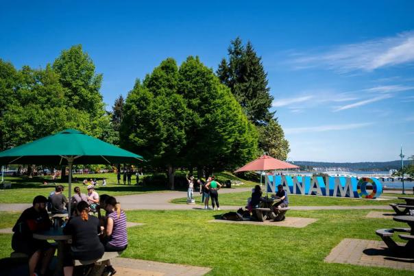 People sitting outside by the Nanaimo sign.