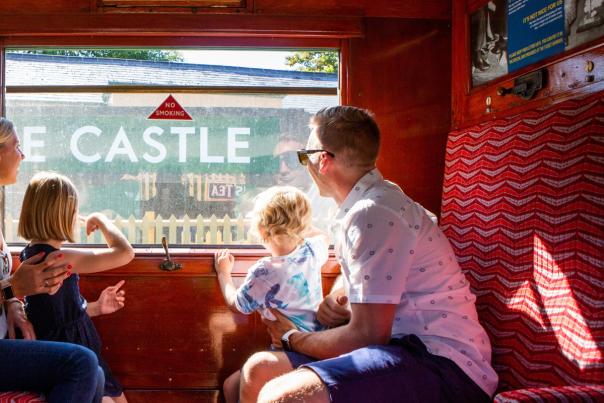 Two adults and two children sitting inside one of the train carriages on the Swanage Railway