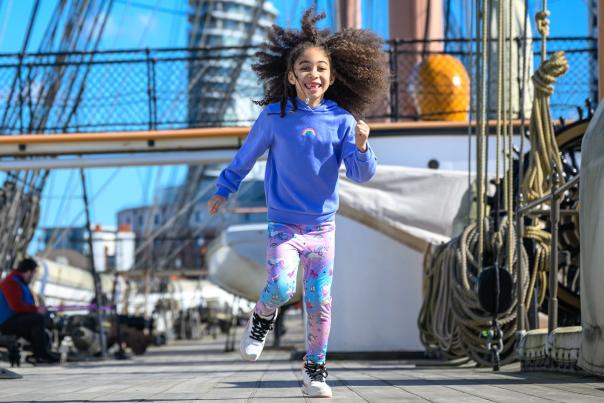 Photograph showing two young children running along the main deck of HMS Warrior at Portsmouth Historic Dockyard