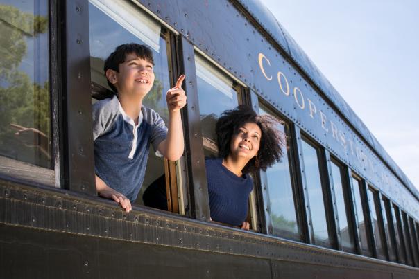 Two people leaning out of a train window.