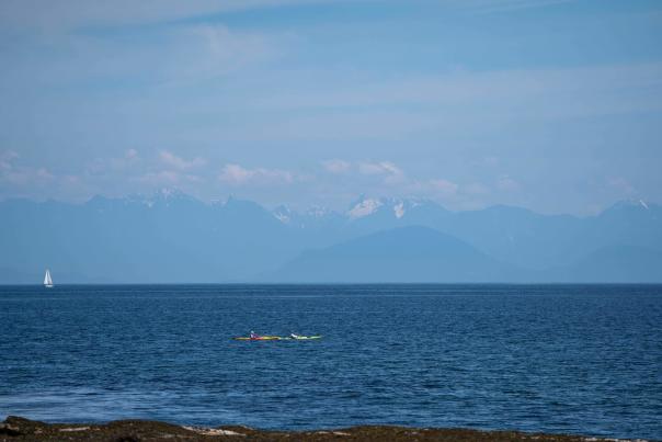 An ocean view with the mountains in the background.