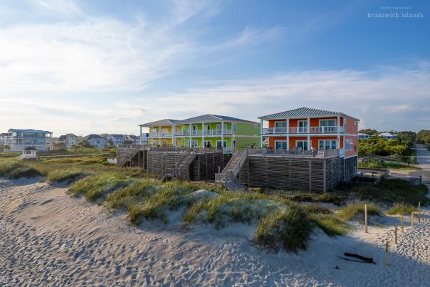 a row of colorful yellow, green, and red homes on oak island, nc