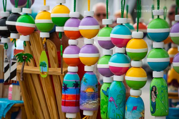 wooden buoys decorated as outdoor decorations for sale at the 2019 NC Festival by the Sea