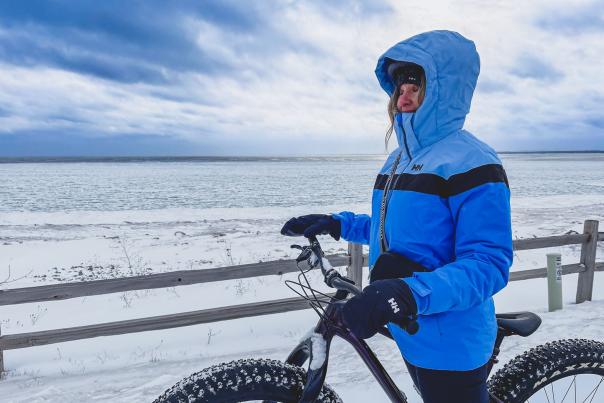 Woman standing with snow bike in front of Lake Superior