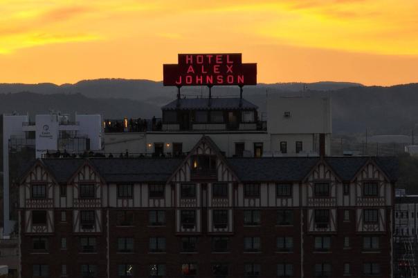 Hotel Alex Johnson sign in front of the sunsetting over the black hills in rapid city south dakota