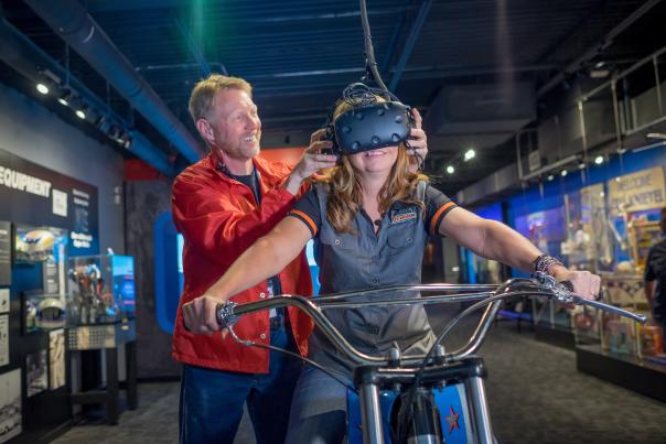 Man puts a helmet on a woman at the Evel Knievel Museum