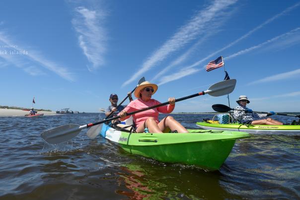 a woman and man in a tandem kayak participating in a group kayaking tour